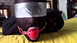 Laura Hard-core is wearing panthyhose and high heels. She's hogtied, masked, blinded and ballgagged